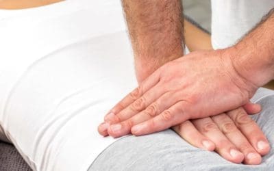Therapist applying pressure on female tailbone.