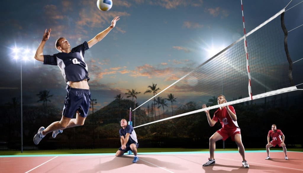 Professional volleyball players in action on the night court