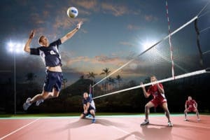 Professional volleyball players in action on the night open air court